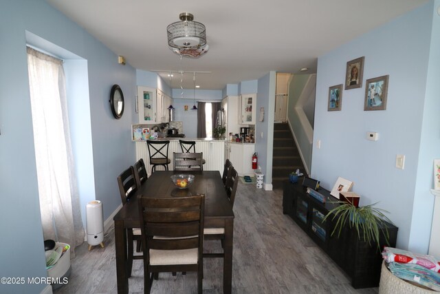 dining area with stairway, wood finished floors, and baseboards