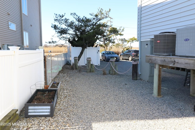 view of yard featuring cooling unit, a garden, and fence