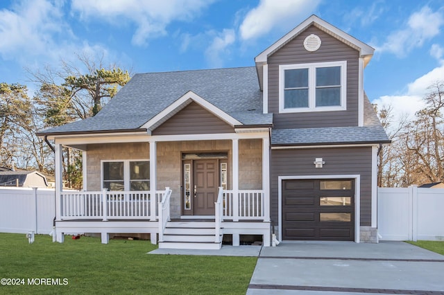 view of front facade featuring covered porch, a garage, and a front yard