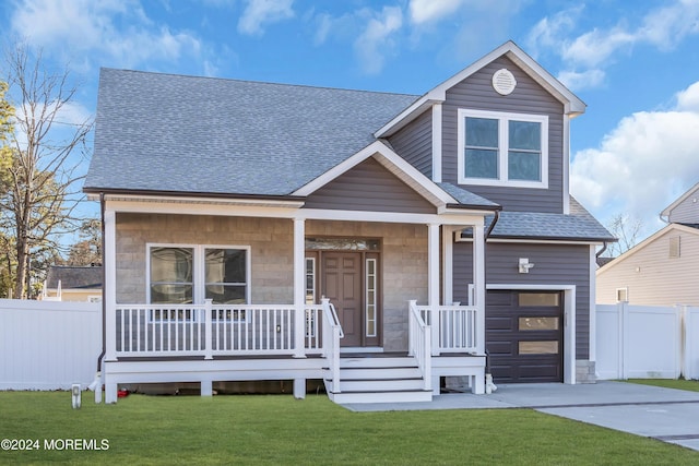 view of front facade featuring a front yard, a garage, and covered porch