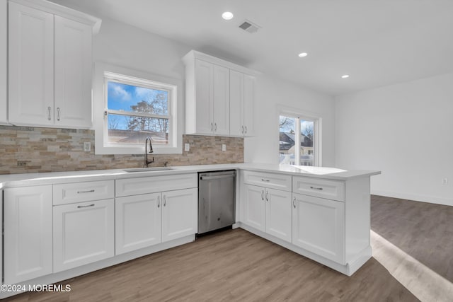 kitchen featuring dishwasher, white cabinetry, light hardwood / wood-style flooring, and sink