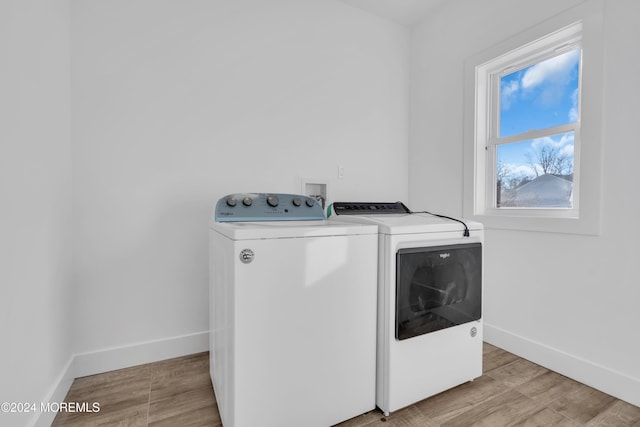 laundry room featuring separate washer and dryer and light hardwood / wood-style floors