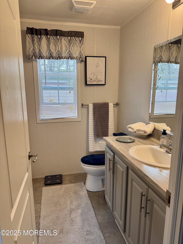bathroom featuring ornamental molding, visible vents, toilet, and vanity