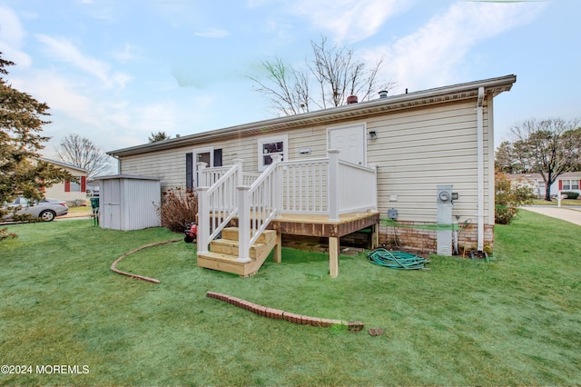 back of house featuring a yard and a storage shed