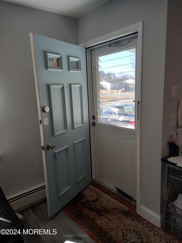 doorway to outside with dark hardwood / wood-style flooring and a baseboard radiator