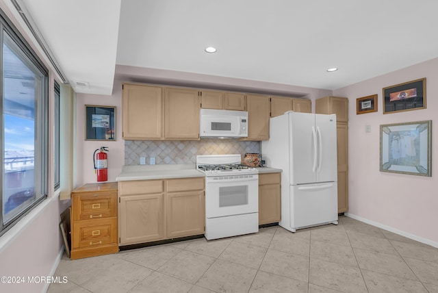 kitchen featuring light tile patterned flooring, white appliances, light brown cabinetry, and tasteful backsplash