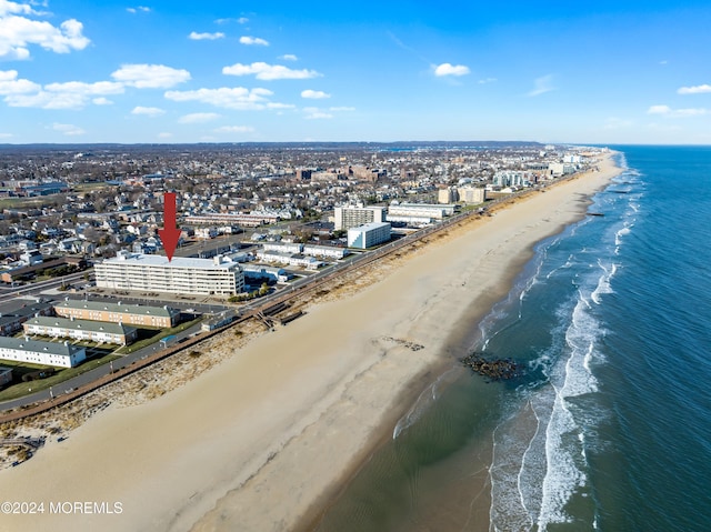 birds eye view of property featuring a water view and a beach view