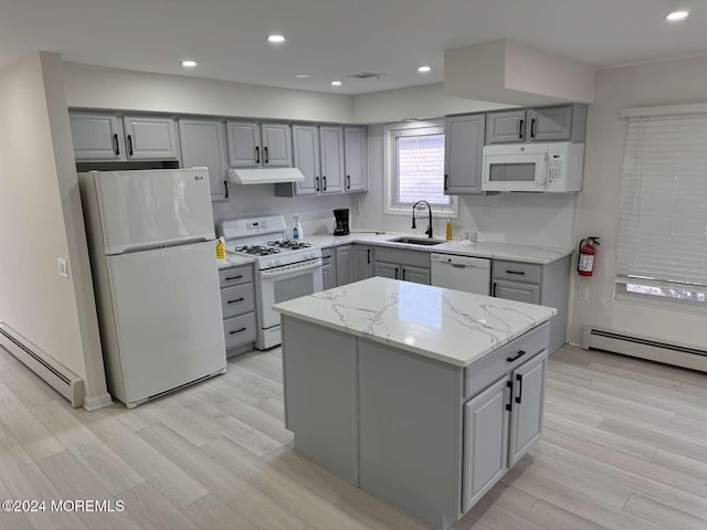 kitchen with light hardwood / wood-style floors, a center island, white appliances, and a baseboard heating unit