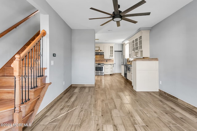 unfurnished living room featuring ceiling fan and light hardwood / wood-style floors