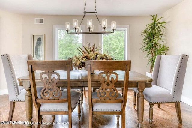 dining room with wood-type flooring and a notable chandelier