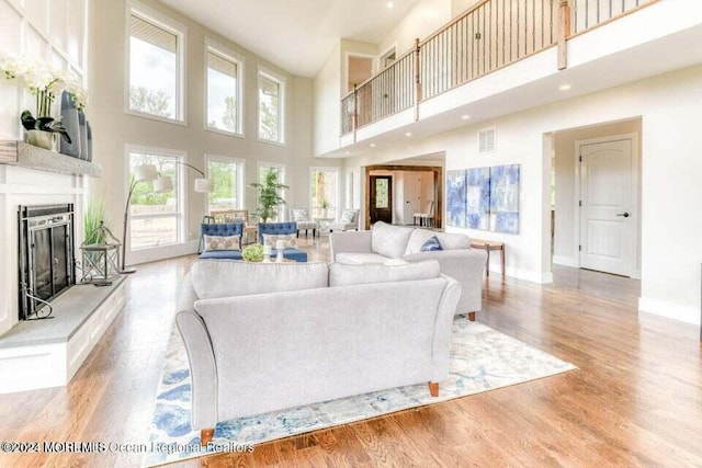 living room featuring light wood-type flooring and a high ceiling