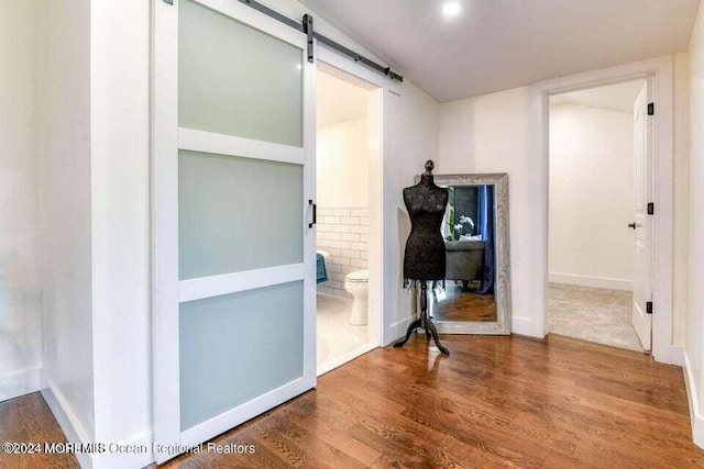 hall featuring hardwood / wood-style floors and a barn door