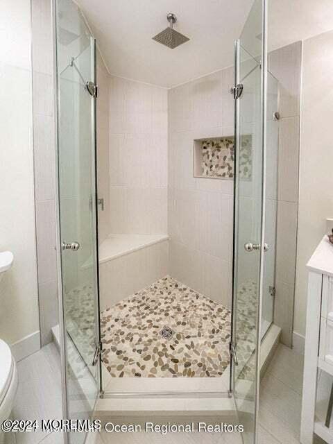 bathroom with toilet and an enclosed shower