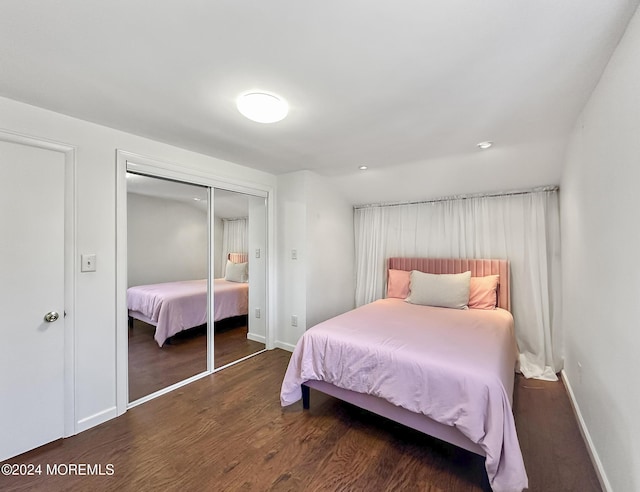 bedroom with dark hardwood / wood-style flooring and a closet