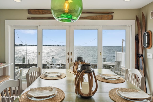 dining area featuring french doors and a water view