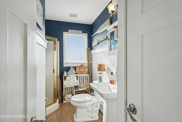 bathroom with wood-type flooring, toilet, and walk in shower