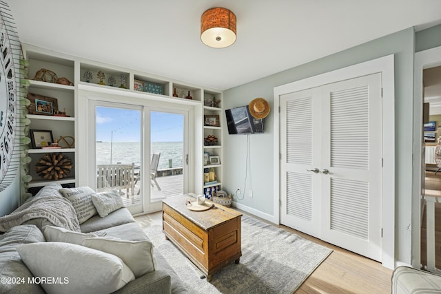 living room featuring built in shelves and hardwood / wood-style flooring