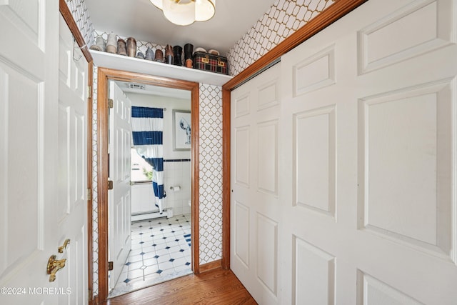 hall with baseboard heating and hardwood / wood-style flooring