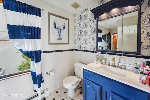 bathroom featuring vanity, baseboard heating, toilet, and tile walls