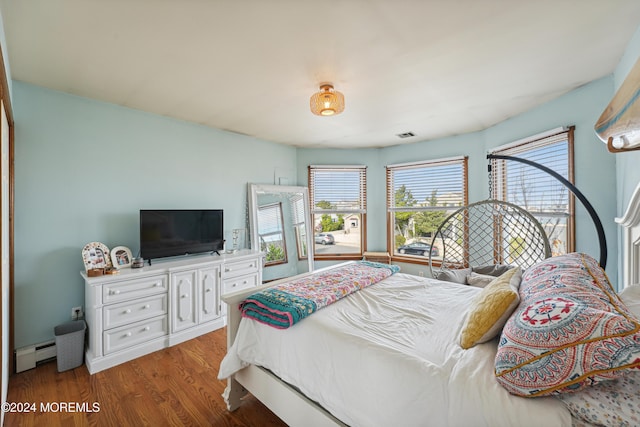 bedroom with hardwood / wood-style flooring and baseboard heating