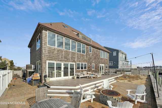 rear view of house with a patio, a deck, and an outdoor fire pit