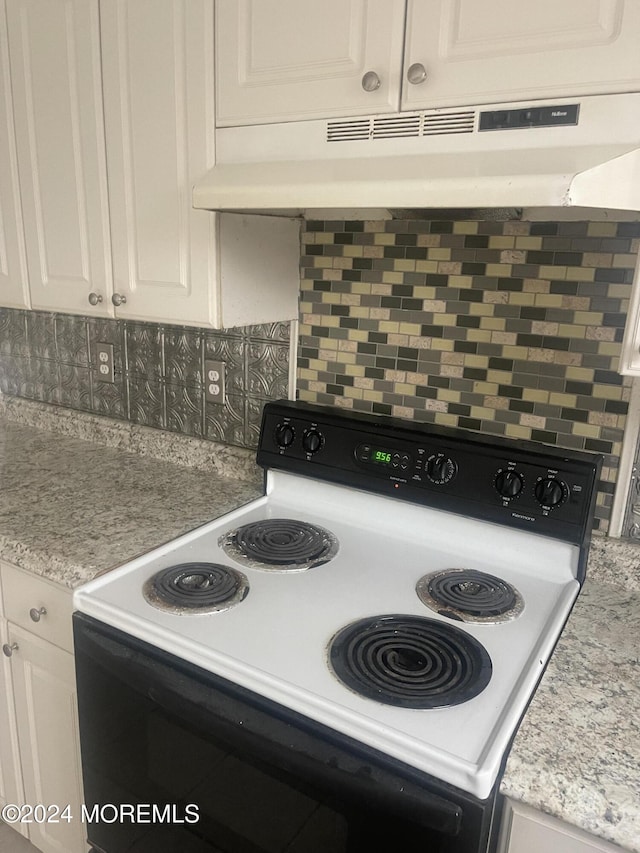 kitchen with white cabinets, light stone countertops, white electric range, and tasteful backsplash