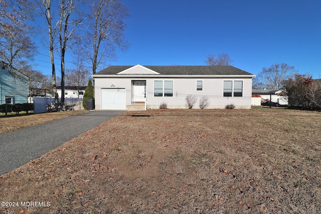 single story home with a garage and a front lawn