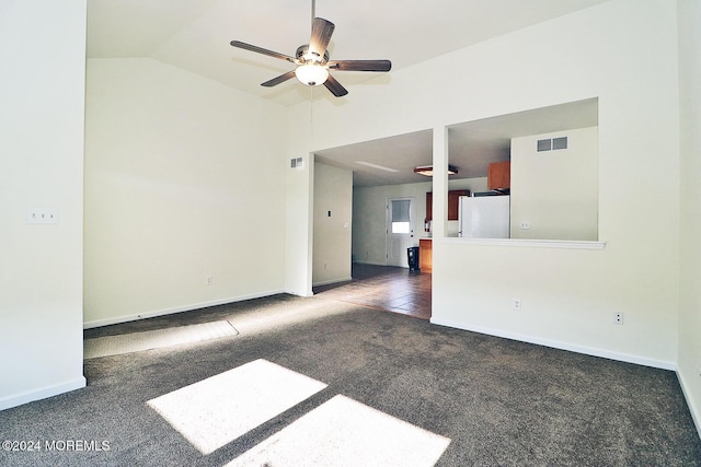 unfurnished living room with ceiling fan, dark carpet, and vaulted ceiling