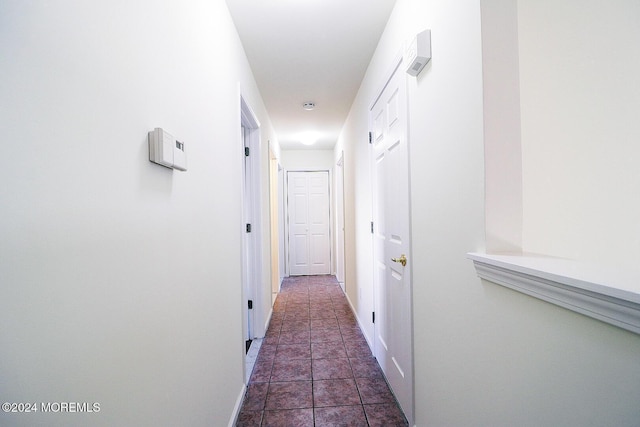 hall featuring dark tile patterned floors