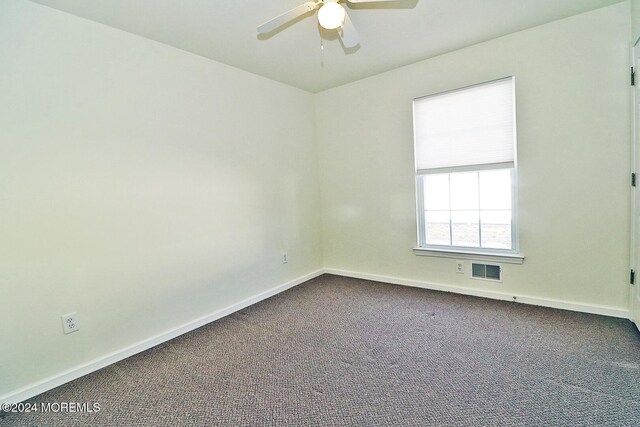 spare room featuring ceiling fan and carpet floors