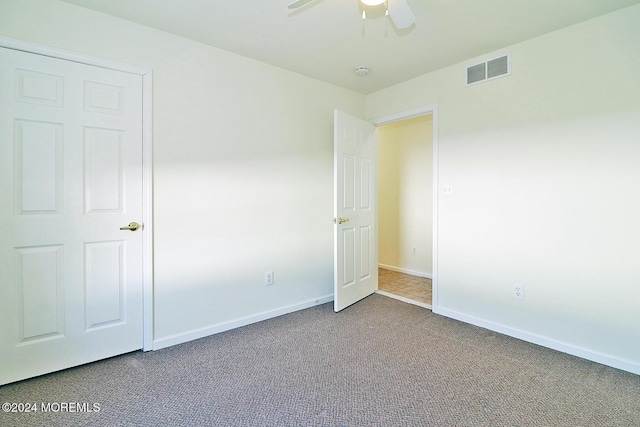 unfurnished bedroom with carpet floors, a closet, and ceiling fan