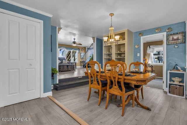 dining space with hardwood / wood-style flooring and ceiling fan with notable chandelier