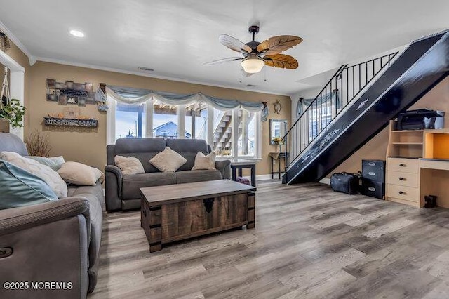 living room featuring ceiling fan, wood-type flooring, and ornamental molding