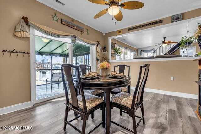 dining room featuring hardwood / wood-style flooring, ornamental molding, and ceiling fan