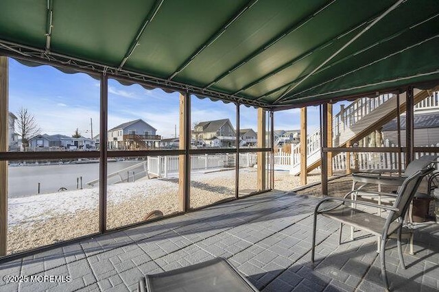 unfurnished sunroom with a water view