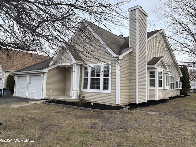 view of property exterior featuring a lawn and a garage