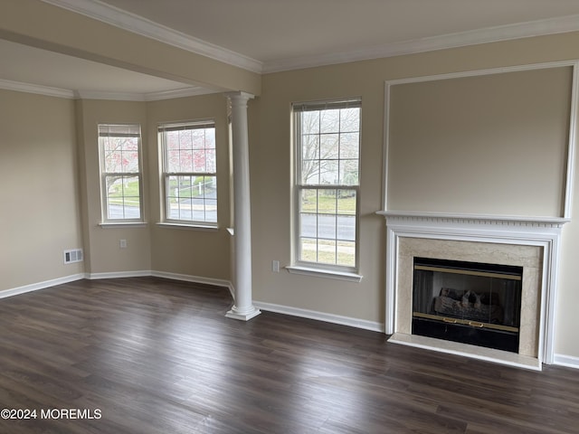 unfurnished living room featuring decorative columns, a fireplace, dark wood-type flooring, and a healthy amount of sunlight