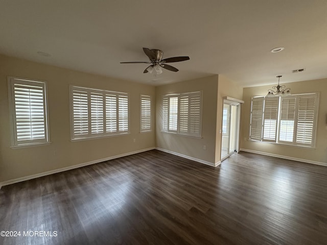 unfurnished room featuring ceiling fan with notable chandelier and dark hardwood / wood-style floors