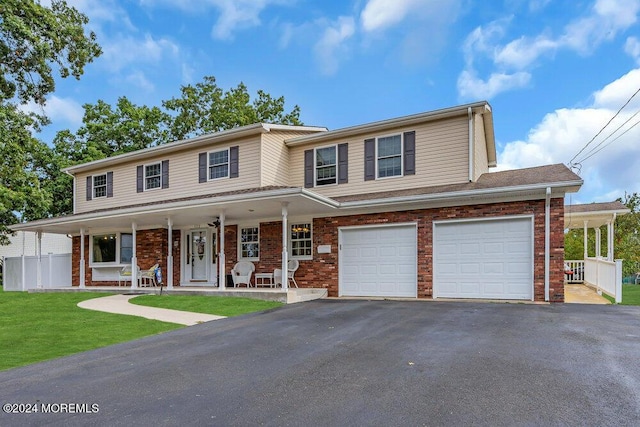 view of front of house with a porch, a garage, and a front lawn