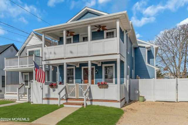 view of front of home with a porch, a balcony, and a front lawn