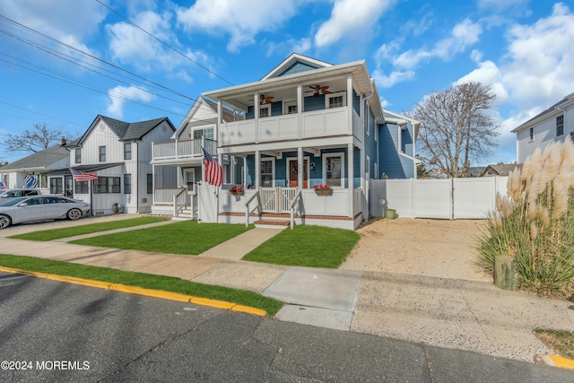 view of front of home with a balcony, a porch, and a front yard