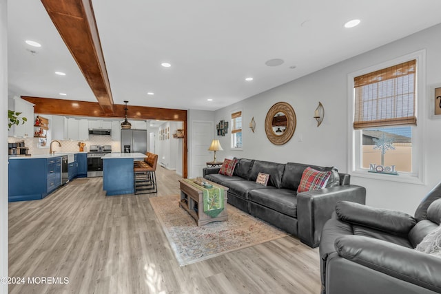 living room with beam ceiling and light hardwood / wood-style floors