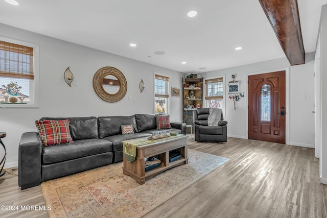 living room featuring light hardwood / wood-style floors and beam ceiling