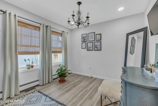 living area with light hardwood / wood-style flooring and an inviting chandelier