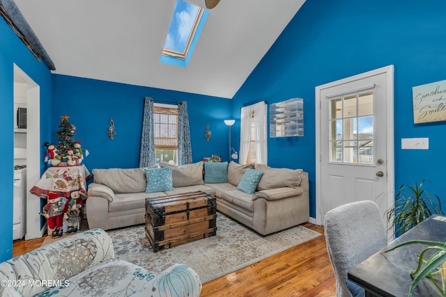 living room featuring wood-type flooring and vaulted ceiling with skylight