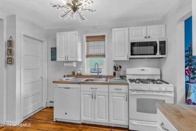 kitchen featuring white appliances, sink, light hardwood / wood-style flooring, an inviting chandelier, and white cabinetry