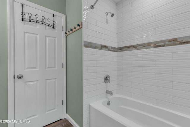 bathroom featuring wood-type flooring and tiled shower / bath combo