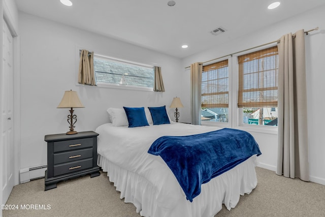 bedroom with light colored carpet and baseboard heating