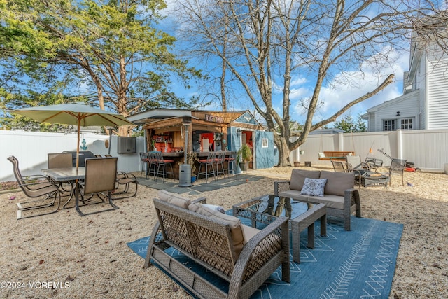 view of patio with an outdoor hangout area, an outbuilding, and an outdoor bar