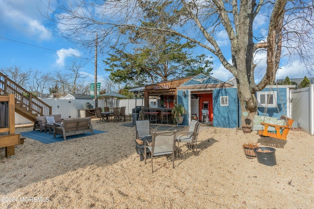 view of front of property featuring an outdoor living space, an outbuilding, and a patio